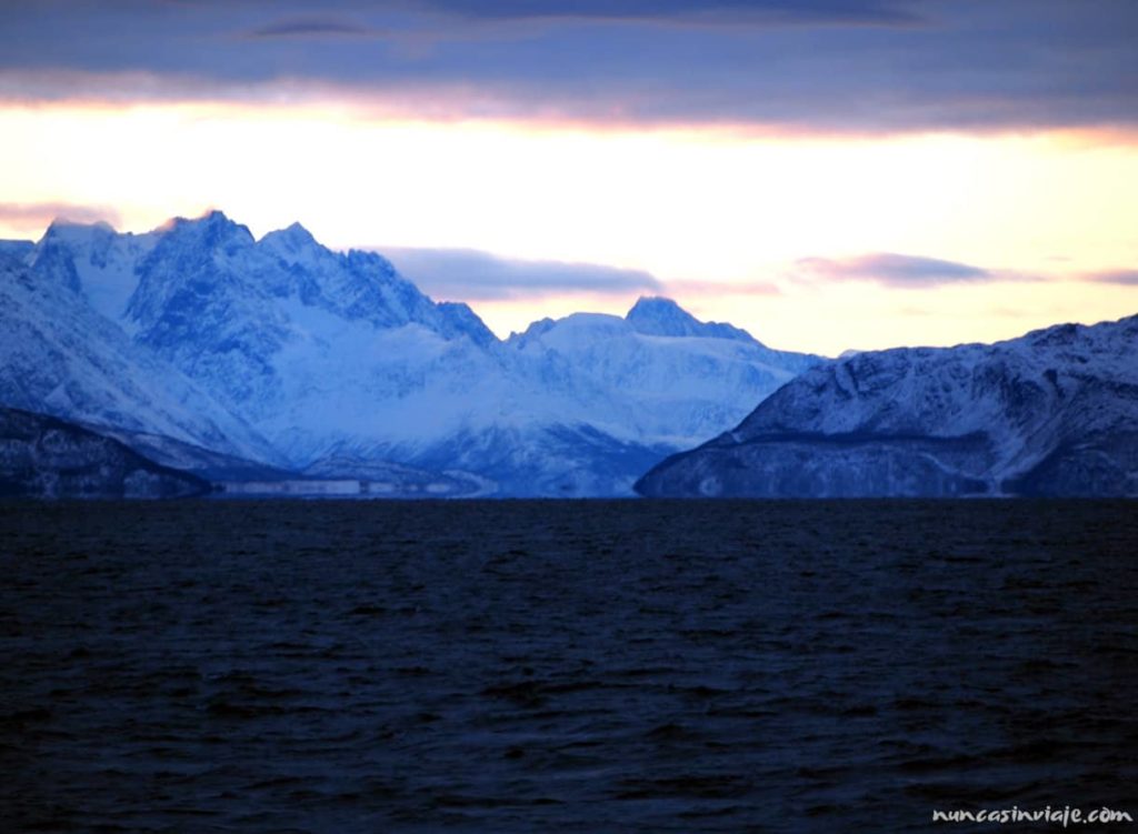 Anochecer en el ártico: el sol se pone detrás de las montañas nevadas