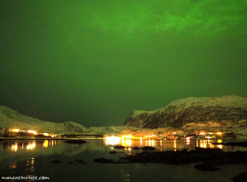 Cielo completamente verde sobre un fiordo cercano a Tromso