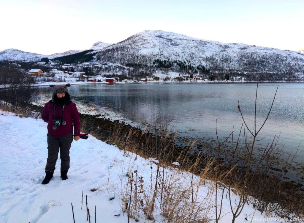 Un pueblo costero rodeado por la nieve frente a uno de los fiordos noruegos